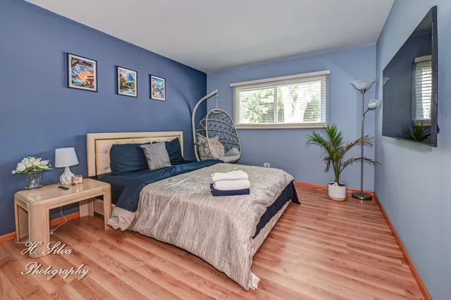 a bedroom with a bed and wooden floor