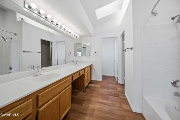 a large bathroom with a double vanity sink a mirror and a bathtub
