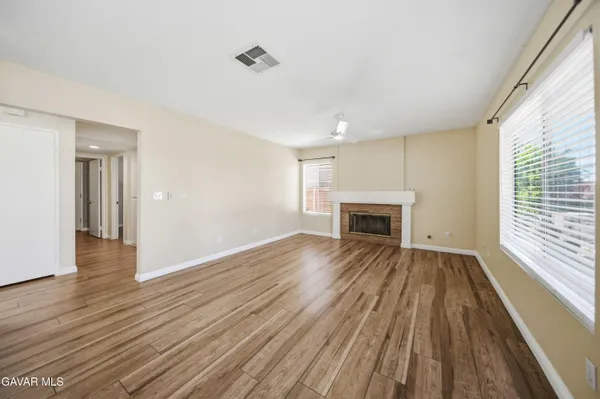 a view of empty room with wooden floor and fireplace