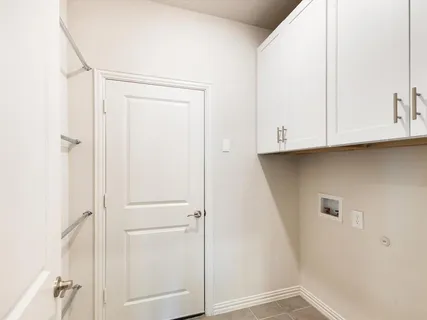 a view of cabinets and utility room with closet