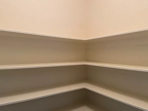 a view of an empty room with wooden floor and a fireplace