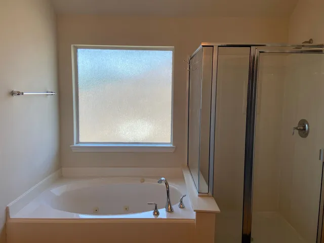 a white bath tub sitting next to a shower