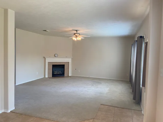 an empty room with fan and fireplace