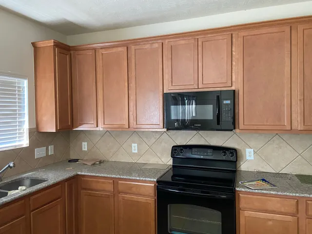 a kitchen with granite countertop a sink and a stove