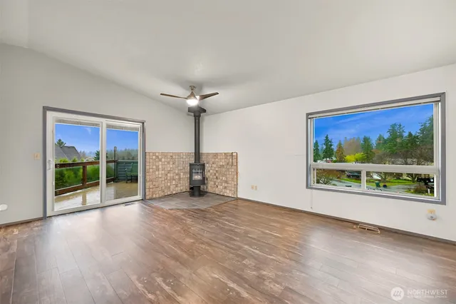 a view of an empty room with a fireplace and a large window