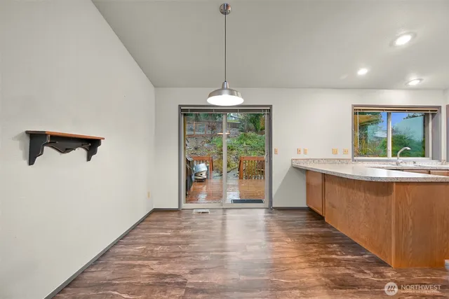 a large kitchen with kitchen island a large window a sink stainless steel appliances and cabinets