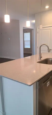a kitchen with a sink a kitchen island with wooden cabinets