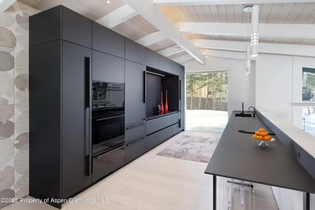 a living room with stainless steel appliances kitchen island granite countertop furniture and a fireplace