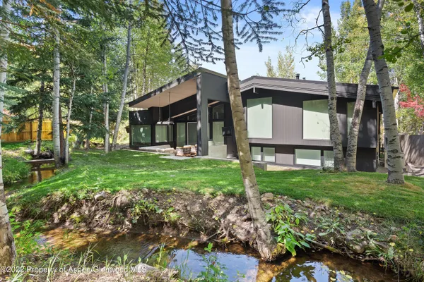 a view of a house with a yard and tree s