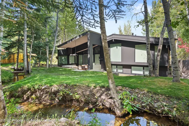 a view of a house with a yard and tree s