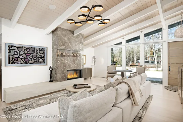 a living room with fireplace furniture and a floor to ceiling window