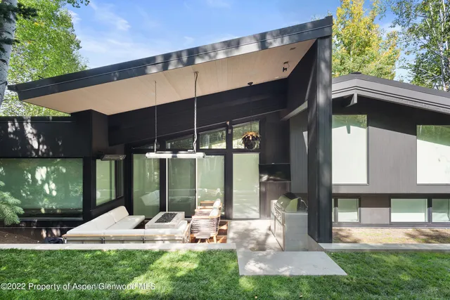 a view of a chair and table in backyard of the house