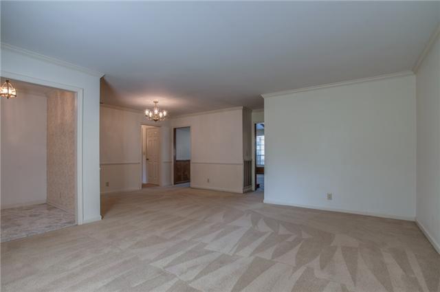 OPEN LIVING SPACE WITH ELEGANT CROWN MOLDING AND CHAIR RAIL IN THE DINING ROOM