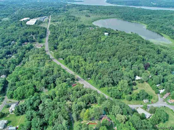 an aerial view of residential house with outdoor space and trees all around
