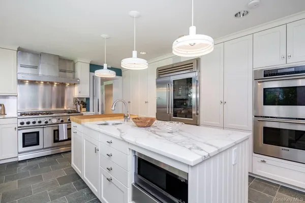 a kitchen with stainless steel appliances white cabinets and a window