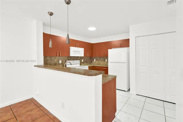 a kitchen with stainless steel appliances granite countertop a refrigerator a oven and a sink with granite countertops