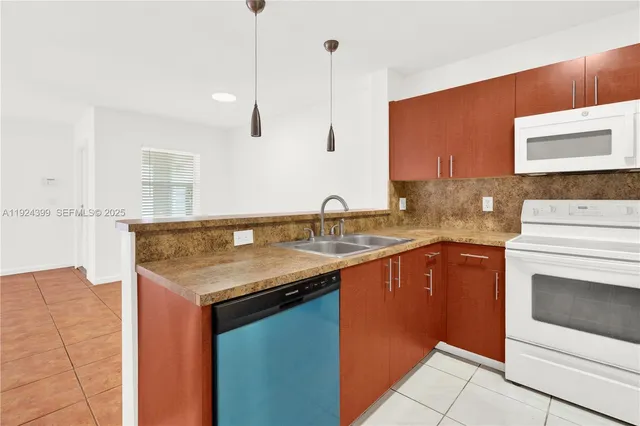 a kitchen with stainless steel appliances granite countertop a sink and a stove
