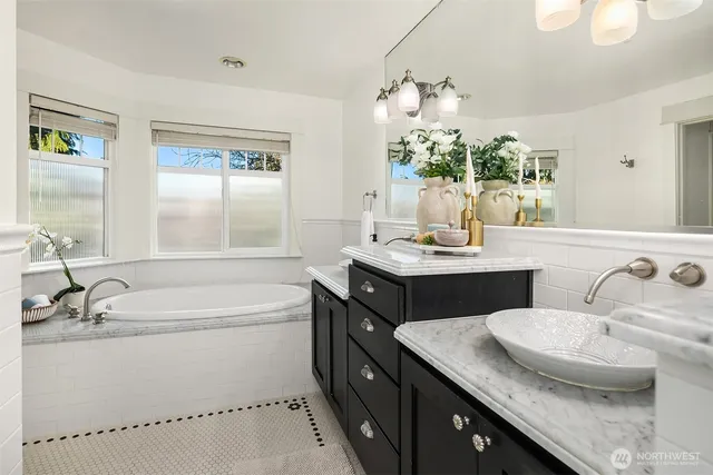 a bathroom with a granite countertop sink mirror and a bathtub