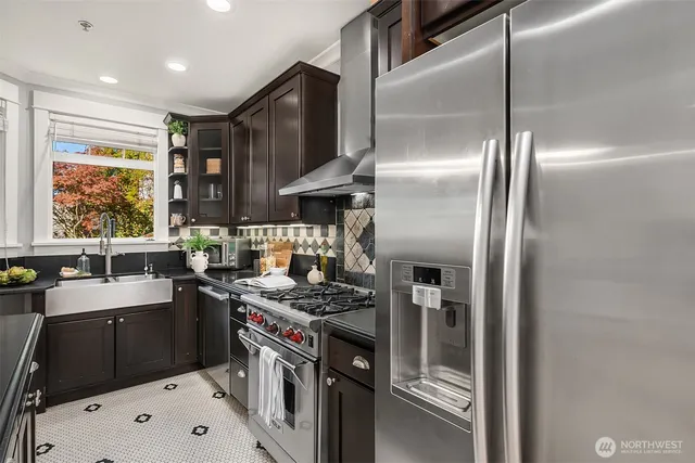 a kitchen with stainless steel appliances granite countertop a sink a stove and a refrigerator