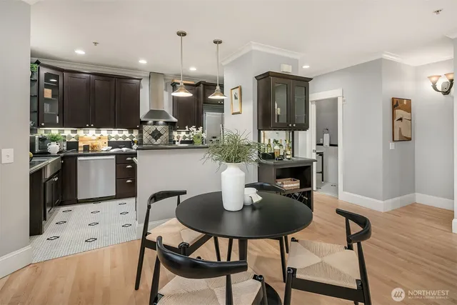 a kitchen with stainless steel appliances kitchen island granite countertop a dining table chairs refrigerator and sink