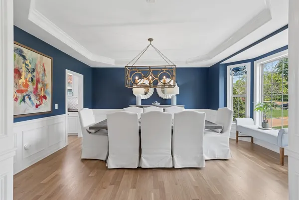 a kitchen with stainless steel appliances granite countertop a refrigerator a stove top oven a sink dishwasher and white cabinets with wooden floor