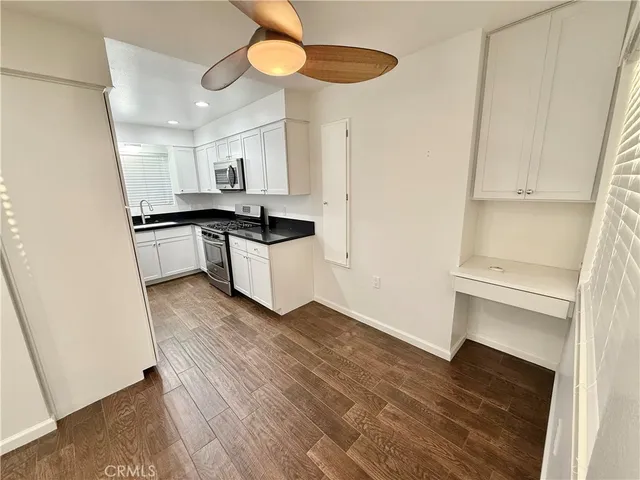 a kitchen with a refrigerator and a stove top oven