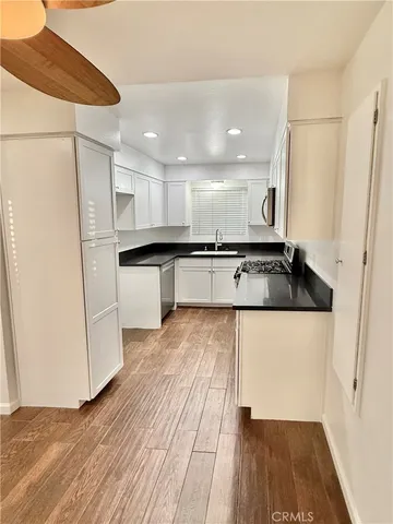 a kitchen with stainless steel appliances granite countertop a refrigerator and a stove top oven