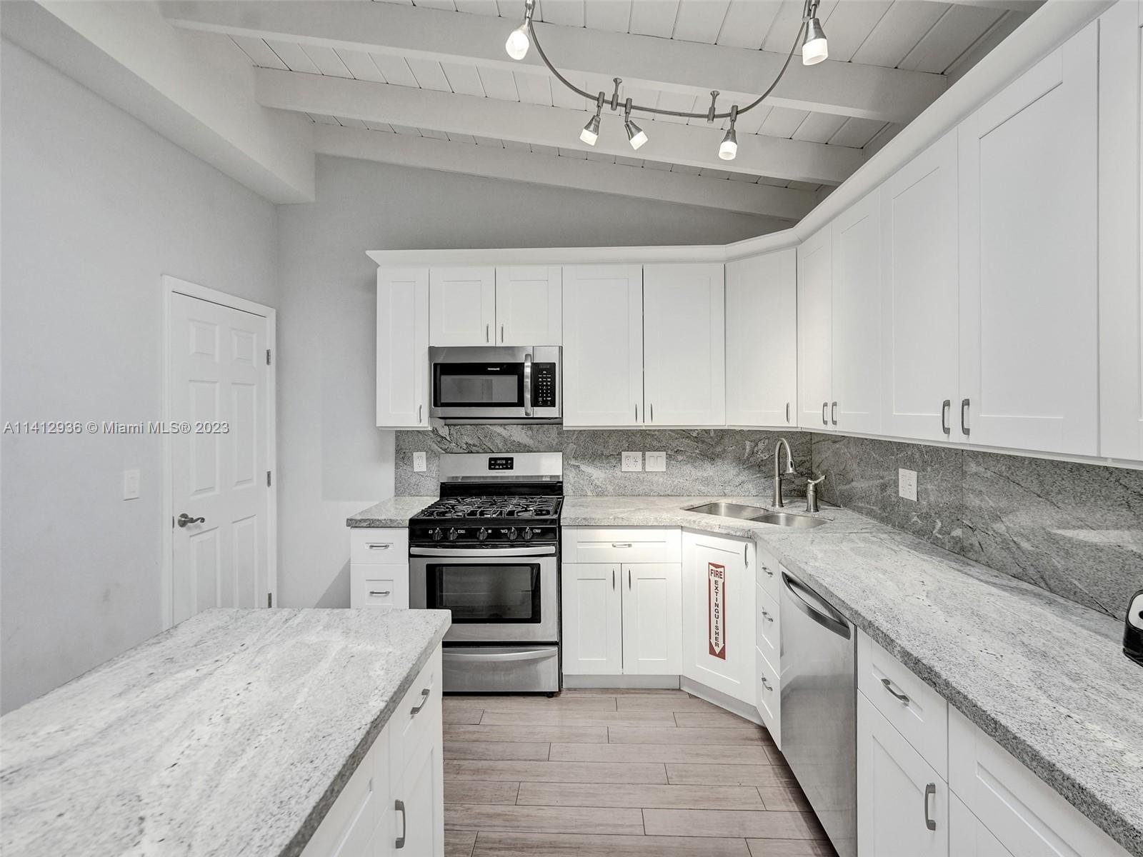 2500 Northeast 19th Street Pompano Beach, FL 33062 - Photo 12 of 51 a kitchen with a sink stove and microwave