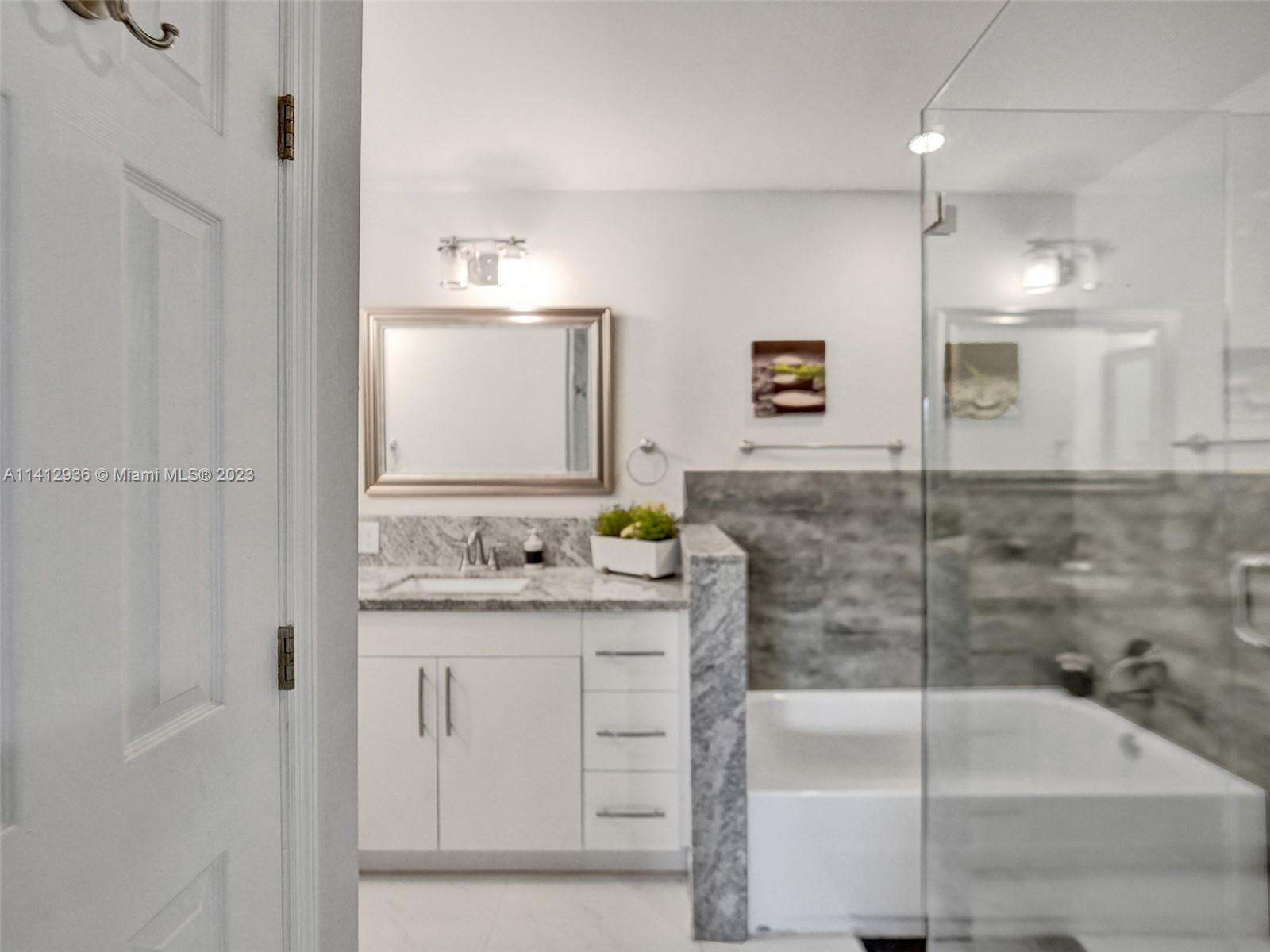 2500 Northeast 19th Street Pompano Beach, FL 33062 - Photo 35 of 51 a bathroom with a granite countertop sink a mirror and a shower