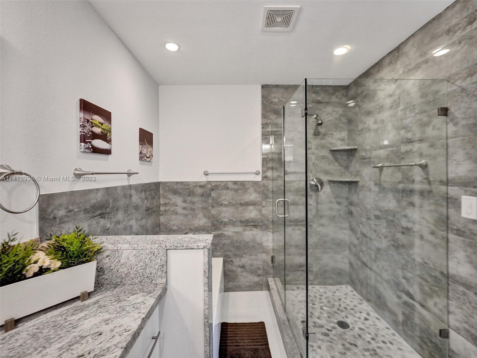 2500 Northeast 19th Street Pompano Beach, FL 33062 - Photo 36 of 51 a bathroom with a granite countertop sink a mirror and shower