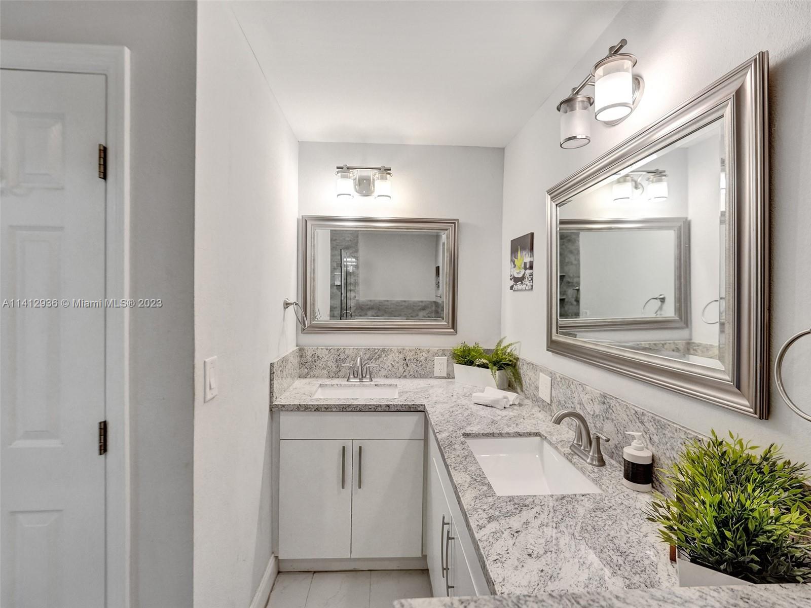 2500 Northeast 19th Street Pompano Beach, FL 33062 - Photo 37 of 51 a bathroom with a granite countertop sink mirror and a bathtub