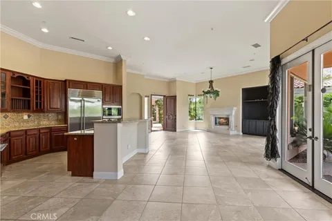 a large empty room with a large window and a refrigerator