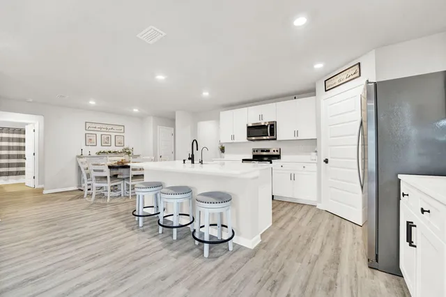 a kitchen with white cabinets and stainless steel appliances