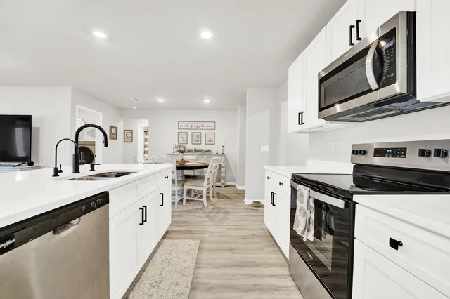 a kitchen with stainless steel appliances a sink stove and cabinets