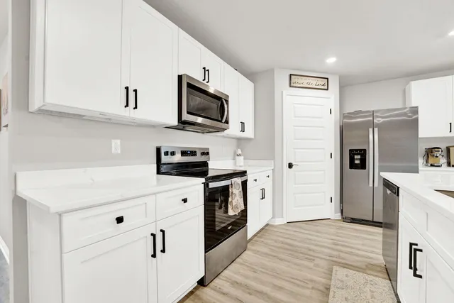 a kitchen with stainless steel appliances white cabinets and refrigerator