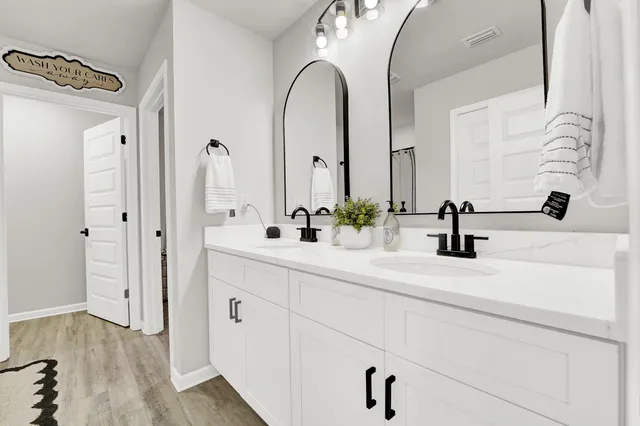a bathroom with double vanity sink and a mirror