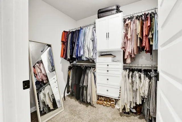 a view of walk in closet with clothes