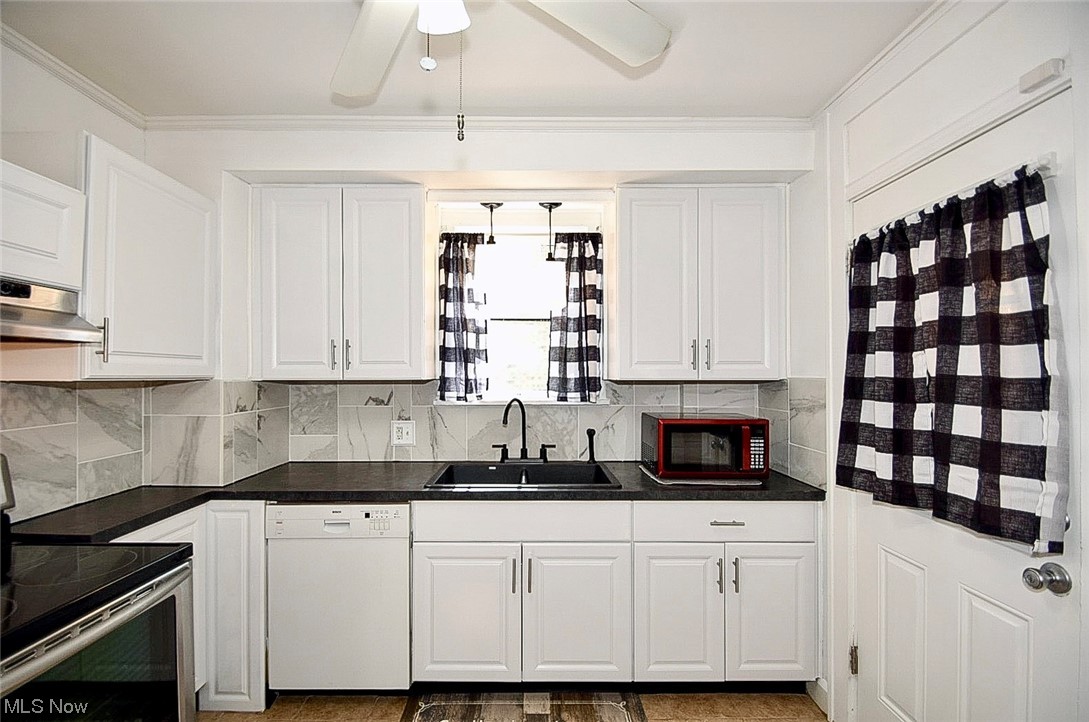 1233 Ridge Road Northwest Canton, OH 44703 - Photo 8 of 24 Kitchen with a notable chandelier, white cabinetry, crown molding, dark countertops, stainless steel range with electric cooktop, white dishwasher, and backsplash