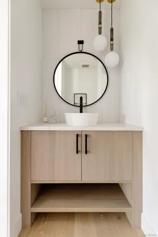 a bathroom with a sink a mirror and a lamp