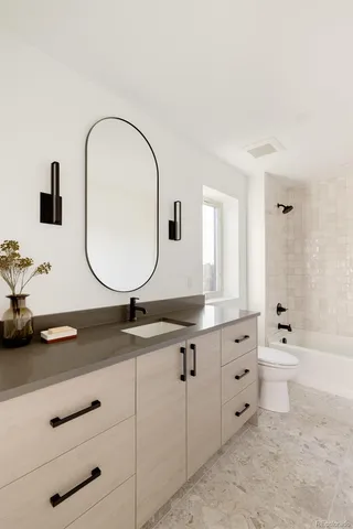 a bathroom with a sink vanity mirror and toilet