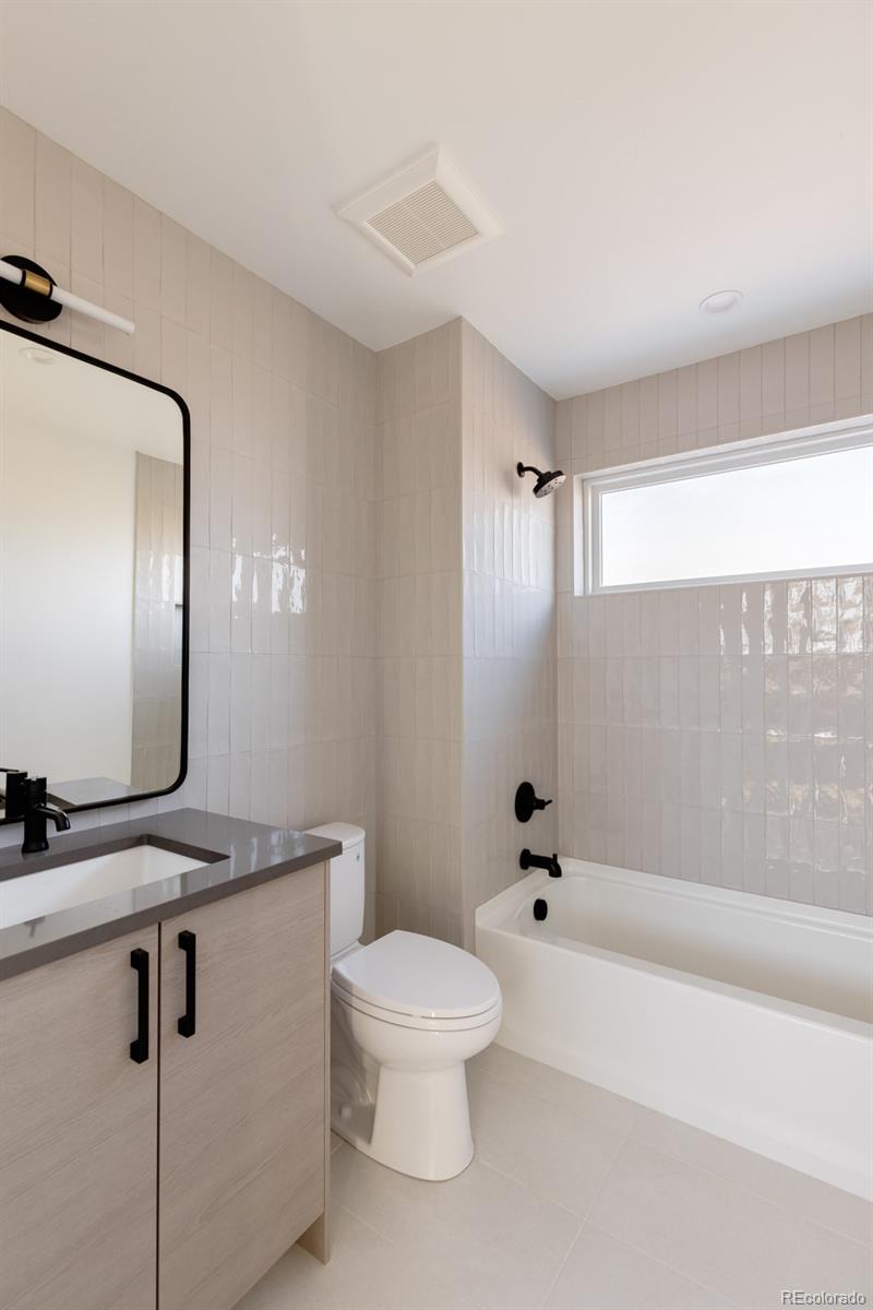 2112 Perry Street Denver, CO 80212 - Photo 25 of 49 a bathroom with a toilet a sink and a mirror