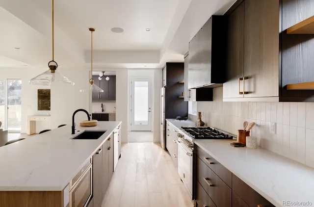 a kitchen with granite countertop a sink a stove and refrigerator