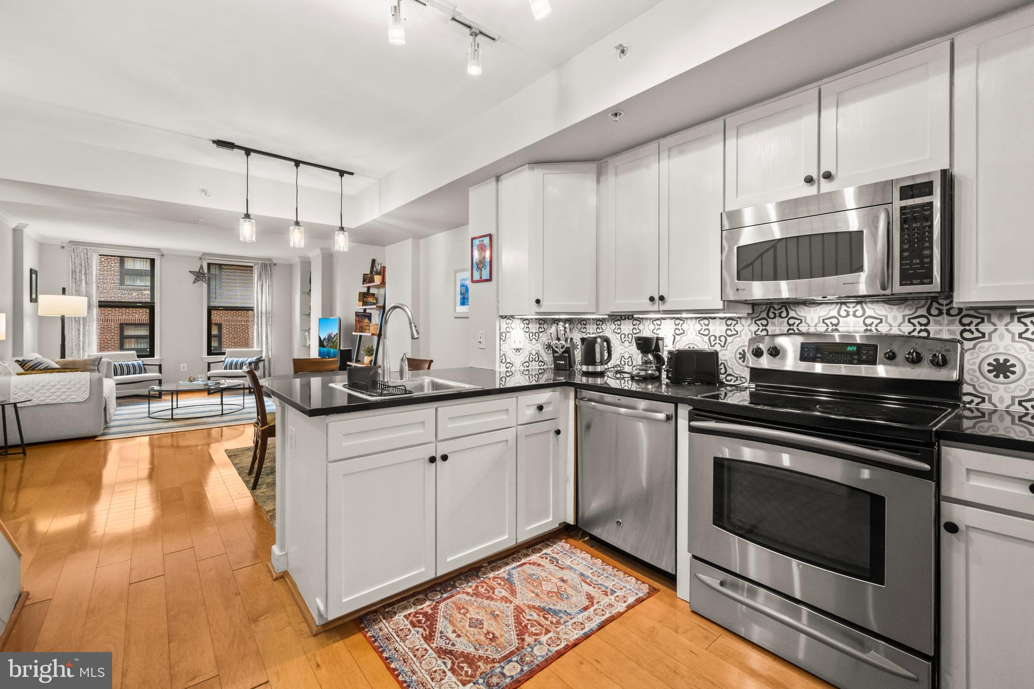 a kitchen with stainless steel appliances granite countertop a stove a sink and a microwave