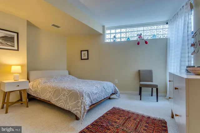 a bedroom with a bed chair and a window