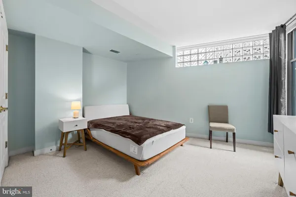 a spacious bedroom with a bed and a lamp