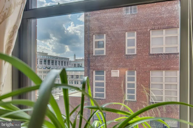 a view of a brick house with a chairs and table in the balcony