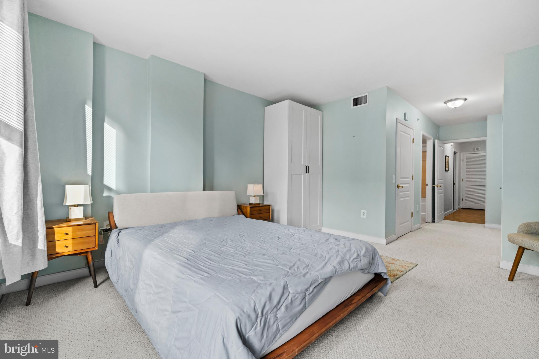 631 D Street Northwest, Unit 845 Washington, DC 20004 - Photo 31 of 84 a spacious bedroom with a bed and a lamp