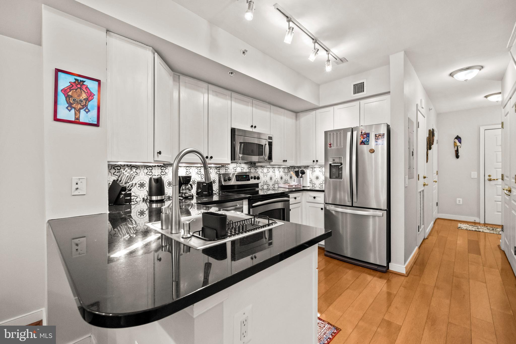 631 D Street Northwest, Unit 845 Washington, DC 20004 - Photo 5 of 84 a kitchen with kitchen island a counter top space a sink stainless steel appliances and cabinets