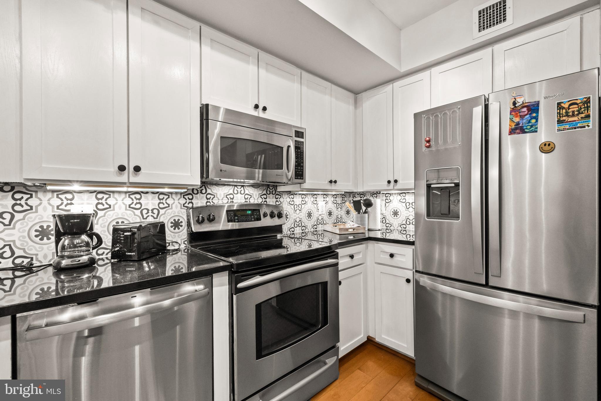631 D Street Northwest, Unit 845 Washington, DC 20004 - Photo 8 of 84 a kitchen with cabinets stainless steel appliances and wooden floor