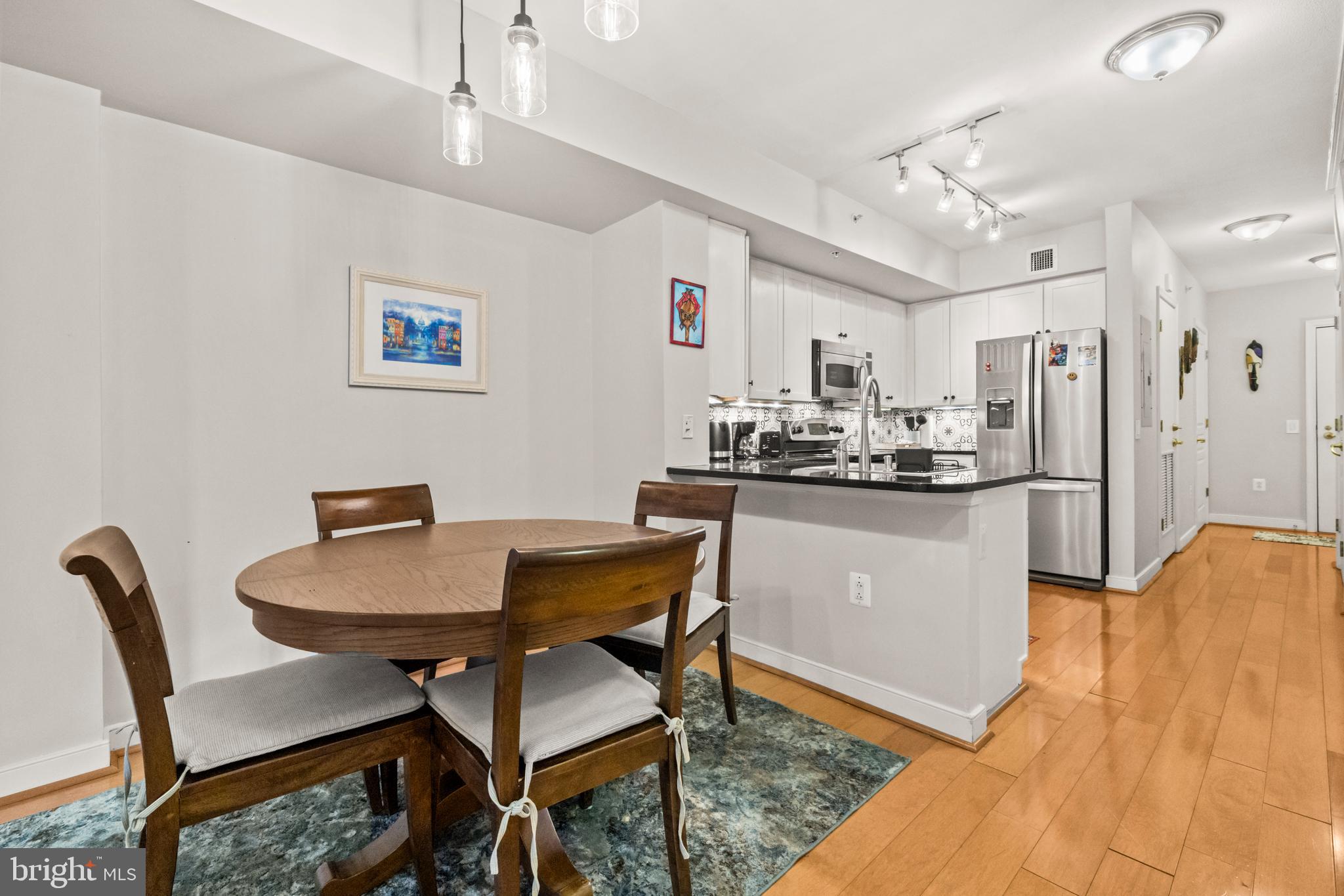 631 D Street Northwest, Unit 845 Washington, DC 20004 - Photo 9 of 84 a dining room with stainless steel appliances kitchen island a table and chairs